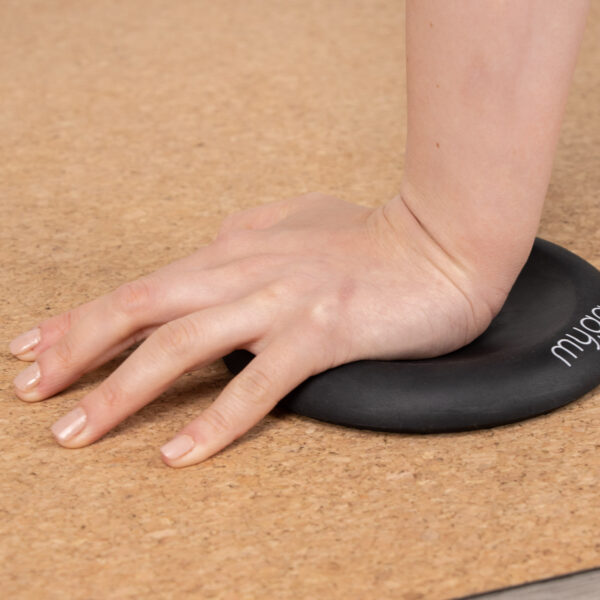 Lifestyle of the black yoga jelly support pad in use with a hand