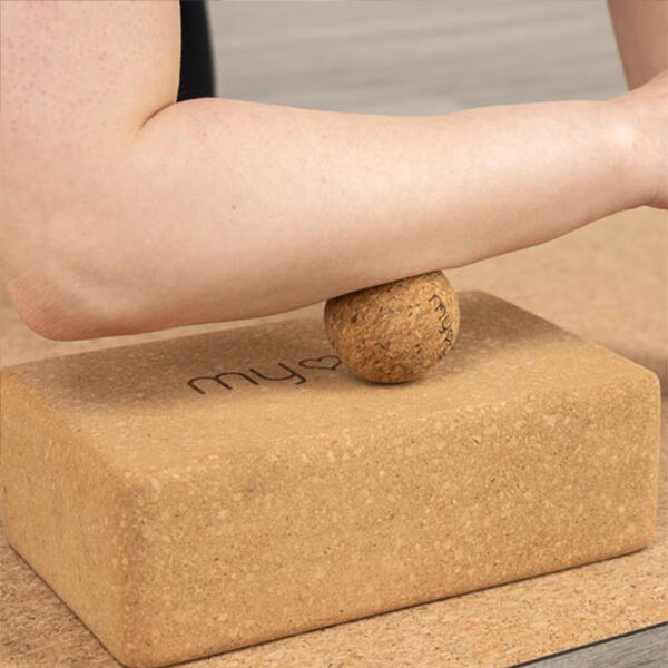 5cm Cork Massage Ball being used on top of cork yoga block whilst massaging the forearm