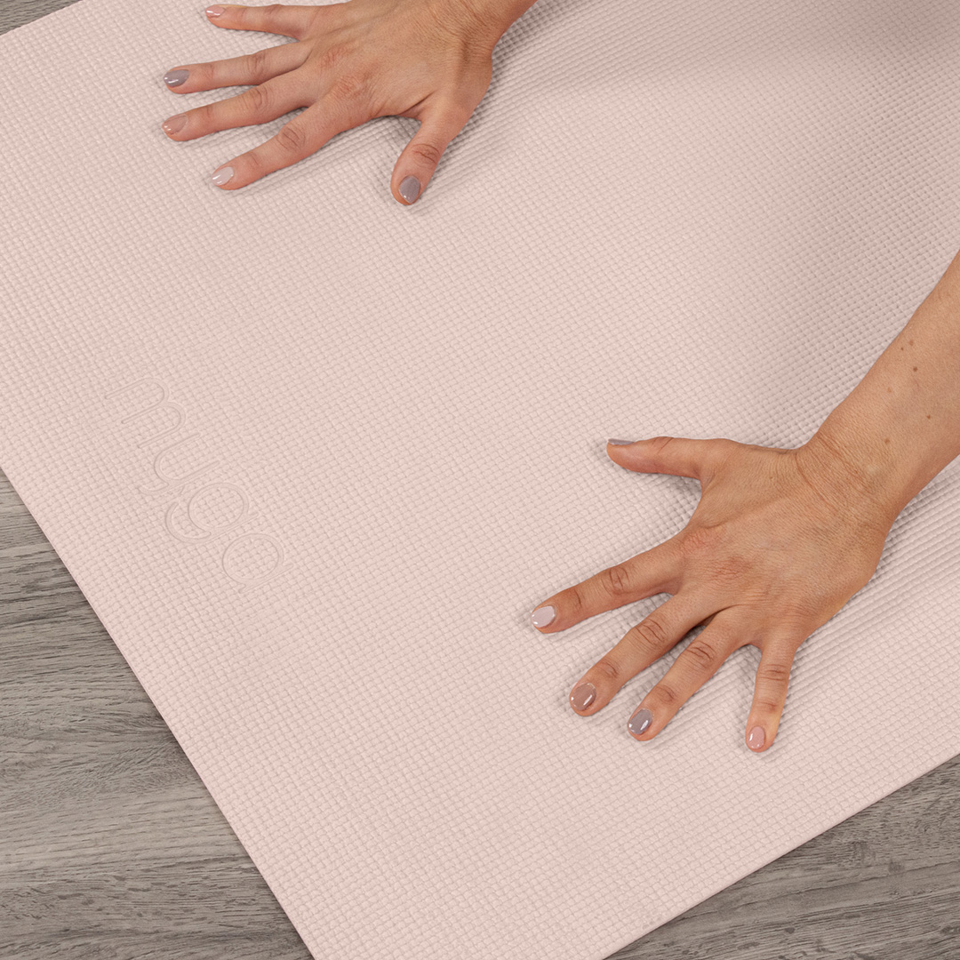 Person practising a beginner yoga pos on a pink mat