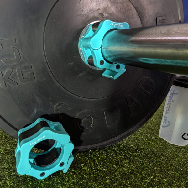 Teal Barbell collars standing bright against black bumper plates