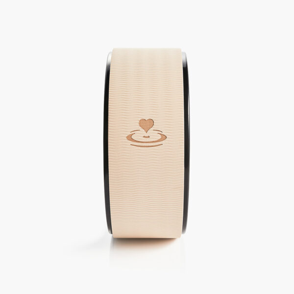 Front view of beige yoga wheel with engraved heart logo, designed for yoga stretching and posture support.