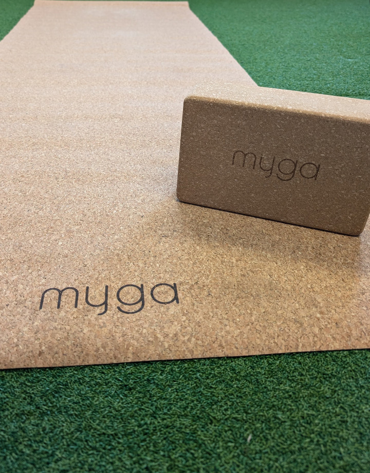 Myga cork yoga mat and yoga block displayed on gym turf at Buds Fitness.
