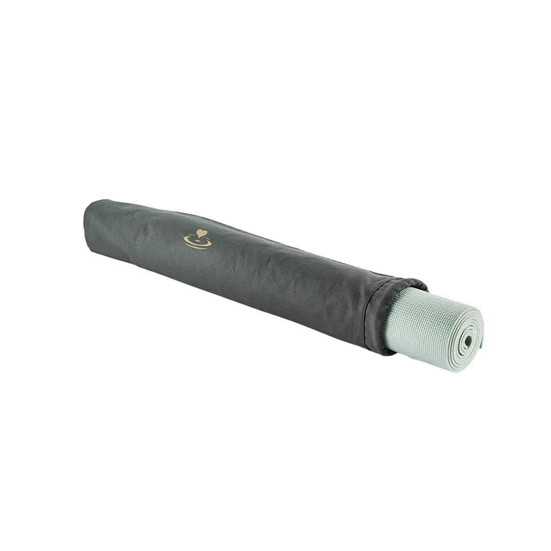 Rolled sage yoga mat sliding into carry bag
