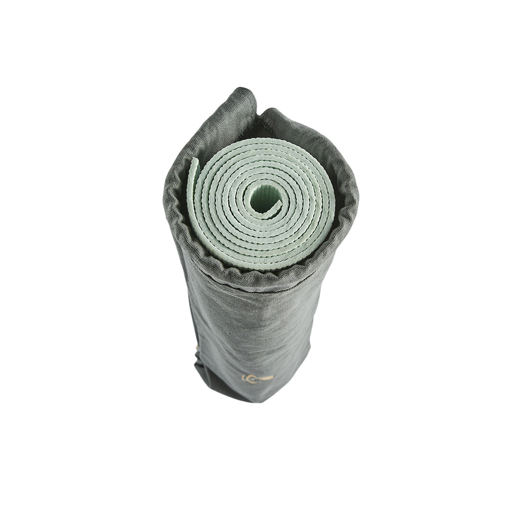 Rolled yoga mat fitted inside cotton yoga mat bag