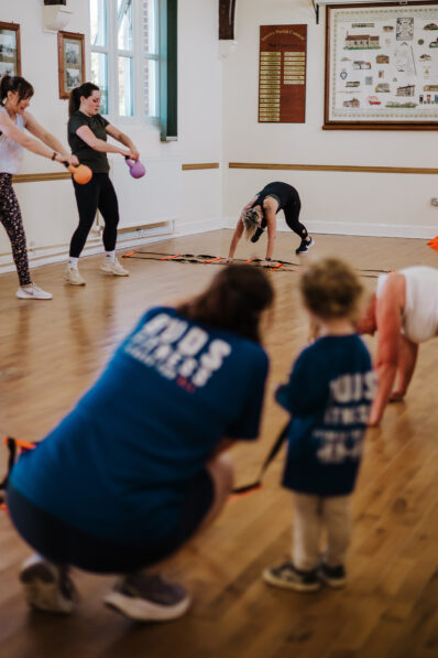 Women exercising with kettlebells while a young child joins the group at a FitFactory exercise class in Sawtry.