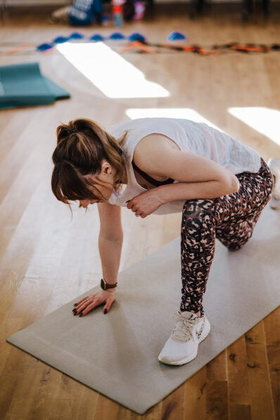 Woman completing a floor-based exercise on a mat during a FitFactory fitness class in Sawtry.